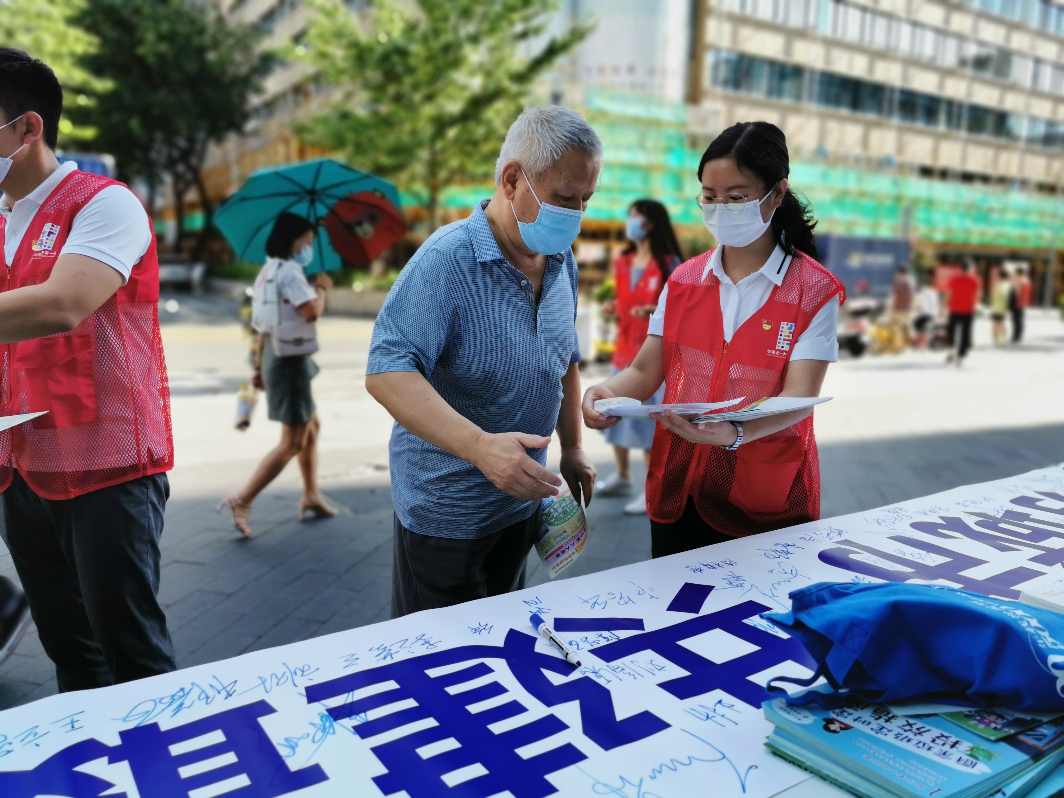 創文宣傳組黨員在振華路向行人發放深圳市“文明公約”、創文宣傳手冊，引導群眾在創文條幅上簽名并向他們宣傳社會主義核心價值觀.jpg